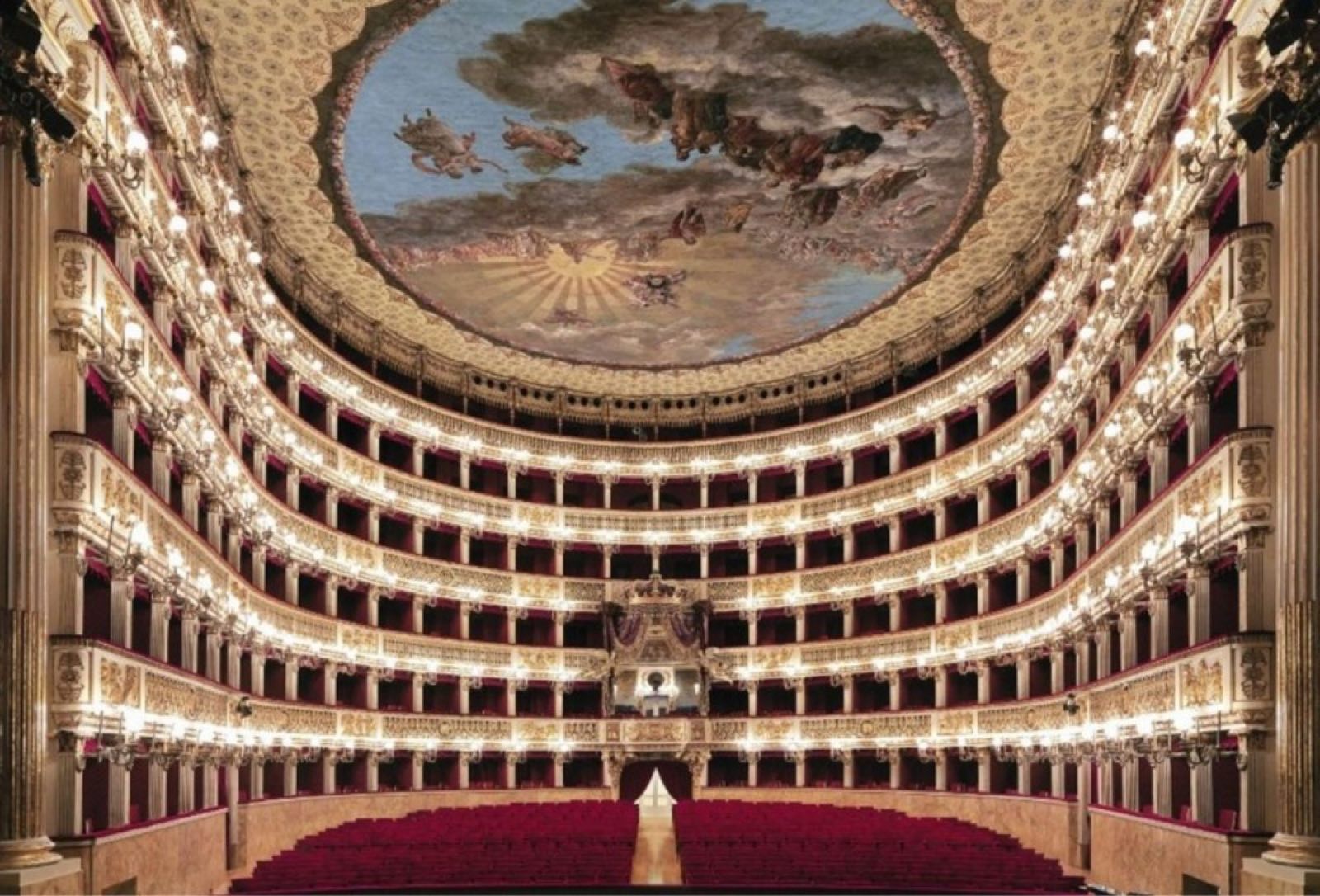 The auditorium of Teatro di San Carlo, with its lit boxes and painted ceiling